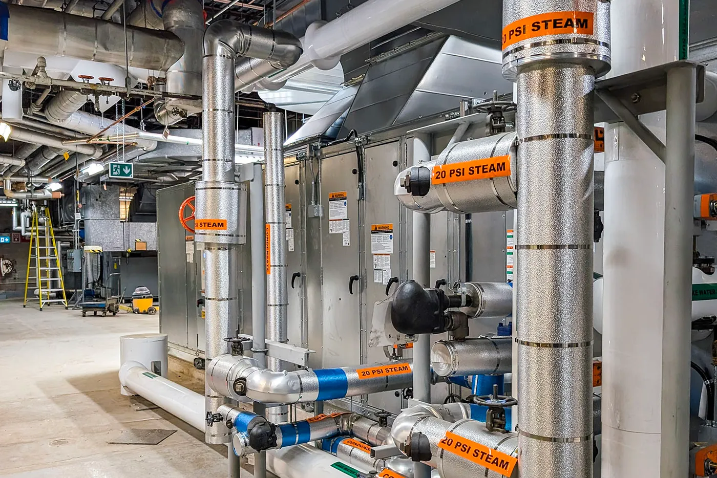 Mechanical room with piping, ducts, and building services equipment.